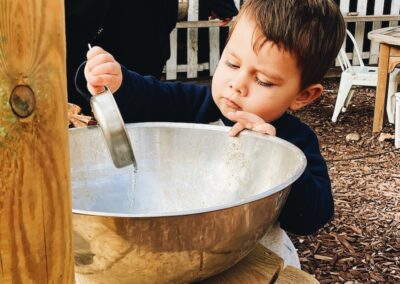 child pours water in bowl