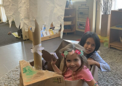 kindergarten students play in cardboard boat