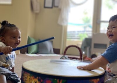 toddlers play on drum