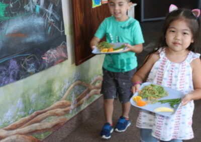 children carry plates of nutritious foods