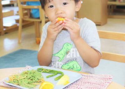 child eats orange has a healthy plate of food