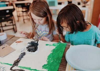 elementary students paint in art class together