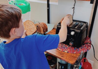 elementary student puts food in toaster