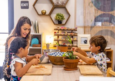 Teacher and two kindergarten students preparing a salad