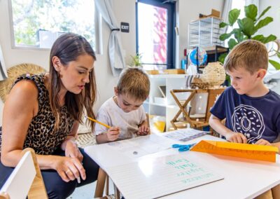 teacher assisting children a kindergarten classroom