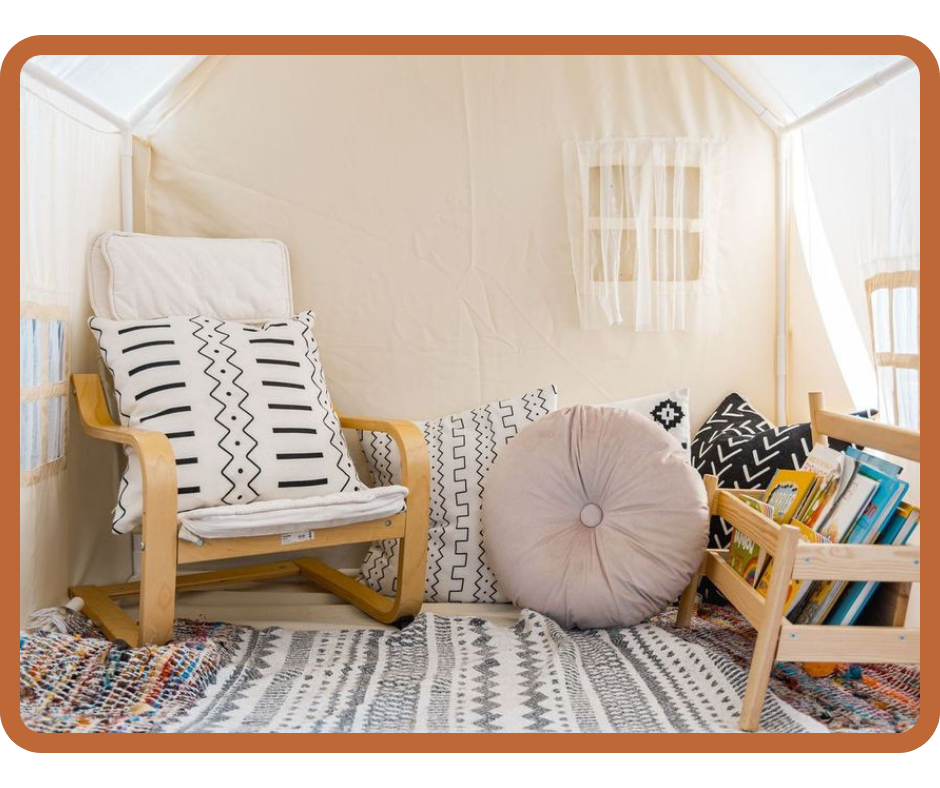 Cozy preschool nook with wooden chair, patterned pillows, round cushion, and small bookshelf