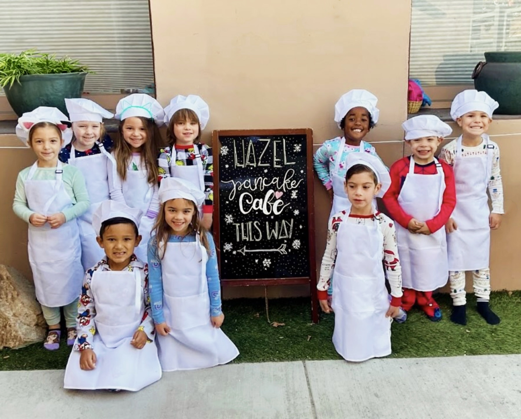 children from hazel room in front of pancake cafe sign